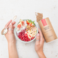 lady holding spoon and recipe bowl of your superfoods energy bomb