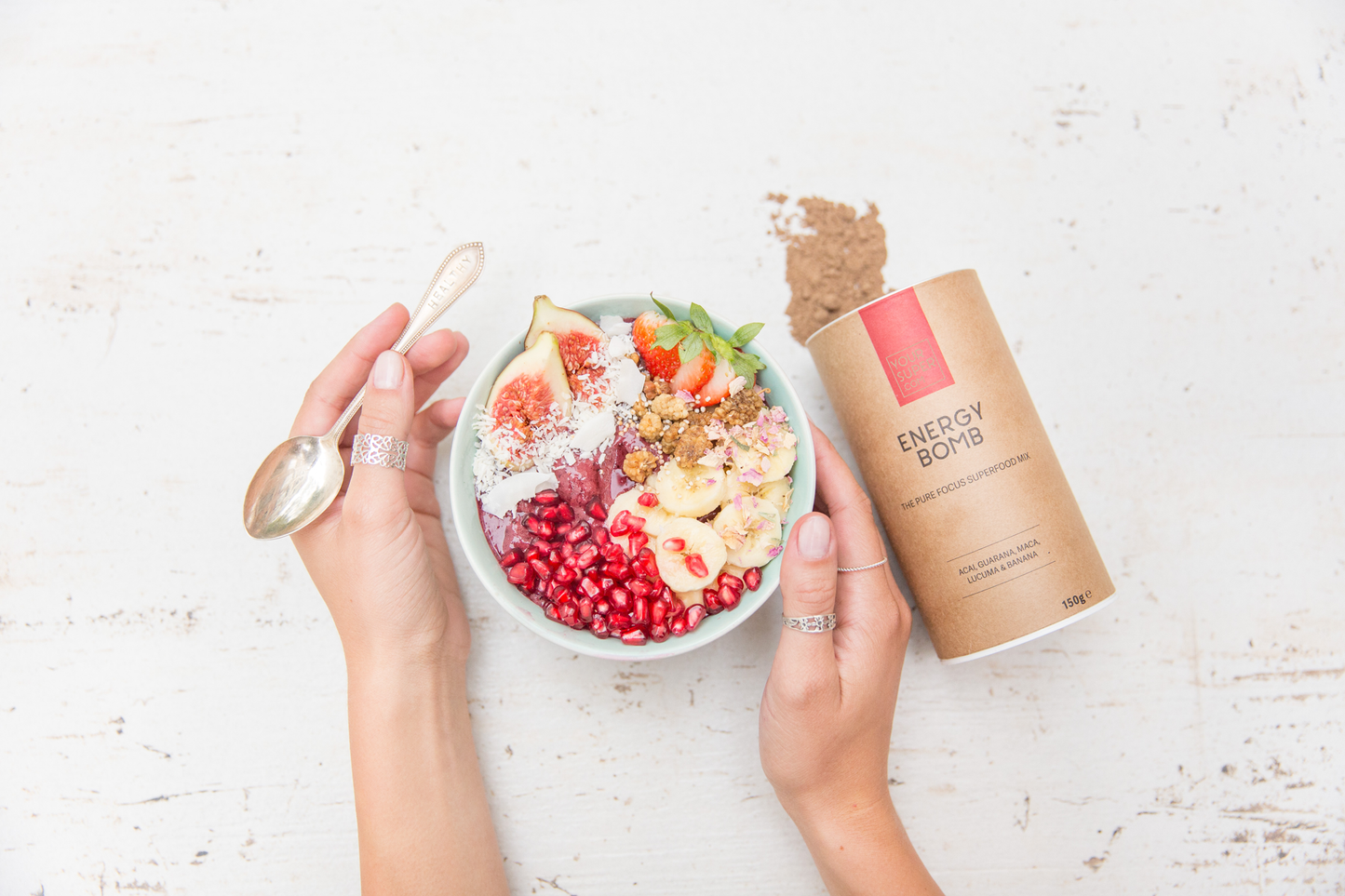 lady holding spoon and recipe bowl of your superfoods energy bomb